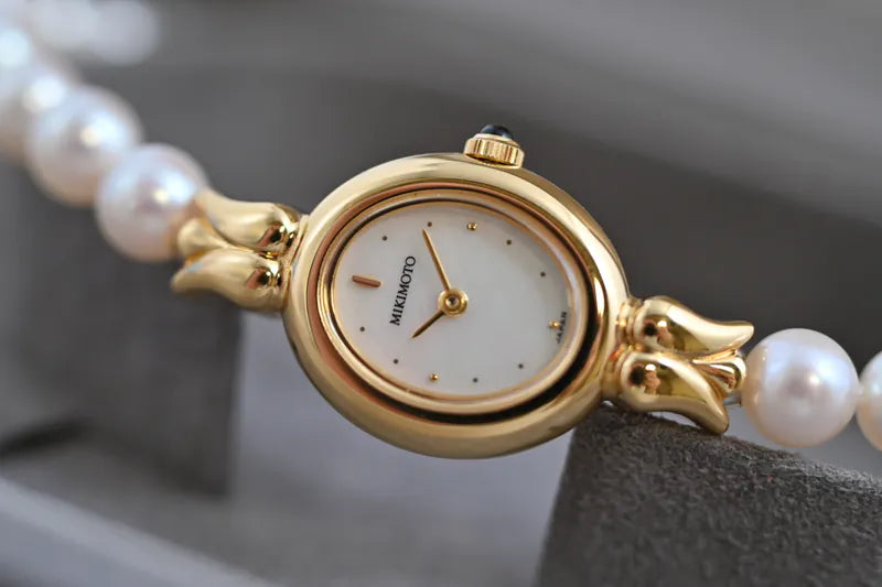 Mikimoto Pearl Bracelet 21mm quartz watch in akoya pearl and 18K gold, featuring round white dial and gold-tone case, front view