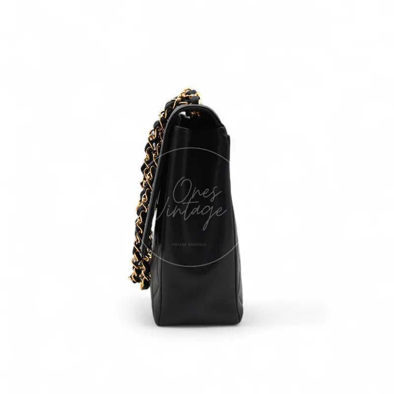 Chanel Vintage Maxi CC Straight Flap Bag in black lambskin, featuring interwoven chain strap and narrow side profile, right side view