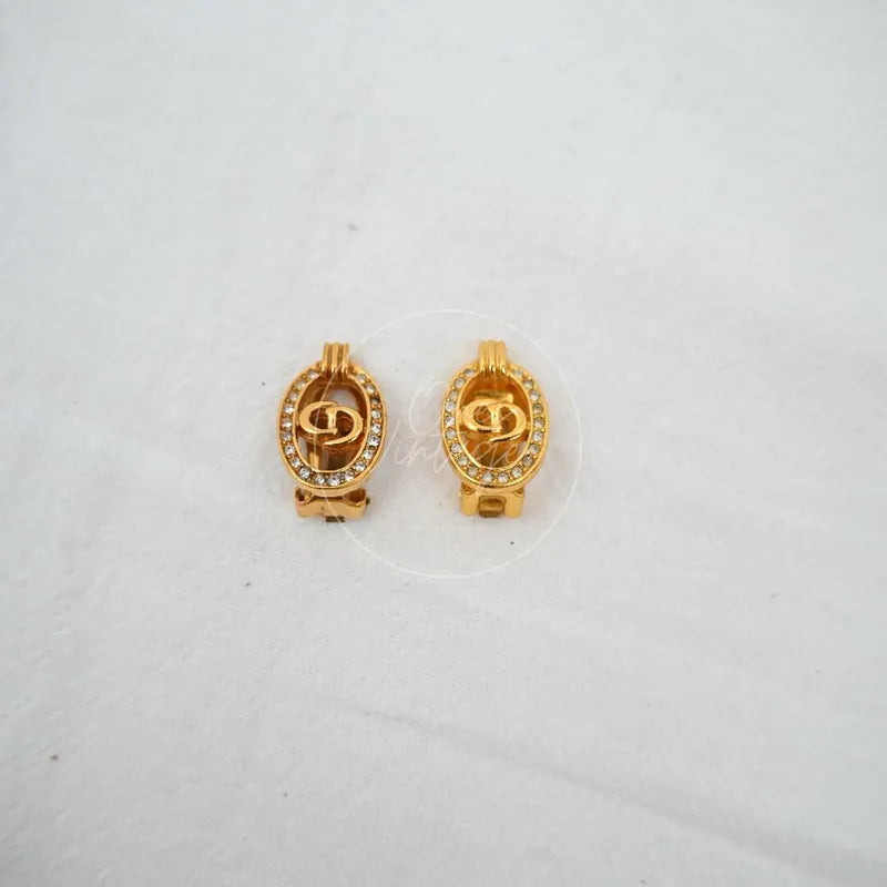 Dior CD Logo Rhinestone Oval Clip Earrings in gold plate, featuring oval rhinestone borders and central CD logo motifs, front view