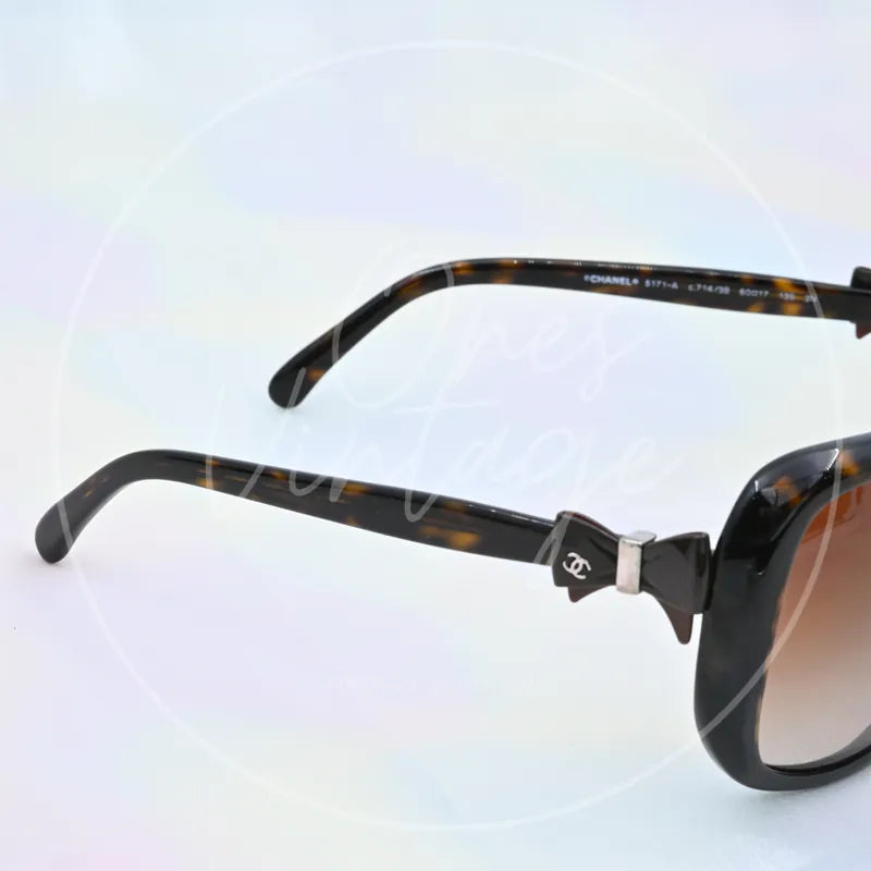 Chanel Sunglasses in black tortoiseshell, featuring interlocking CC hinge logo and tortoiseshell temple arms, front three-quarter view