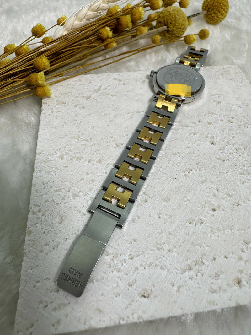 Hermès Classic Clipper watch in stainless steel and gold-plated, featuring folding clasp and round gray dial, front view