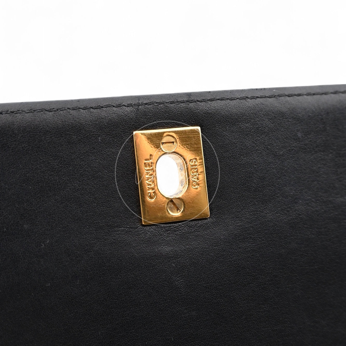 Close-up of gold-tone rectangular plate with CHANEL PARIS engraving inside the flap