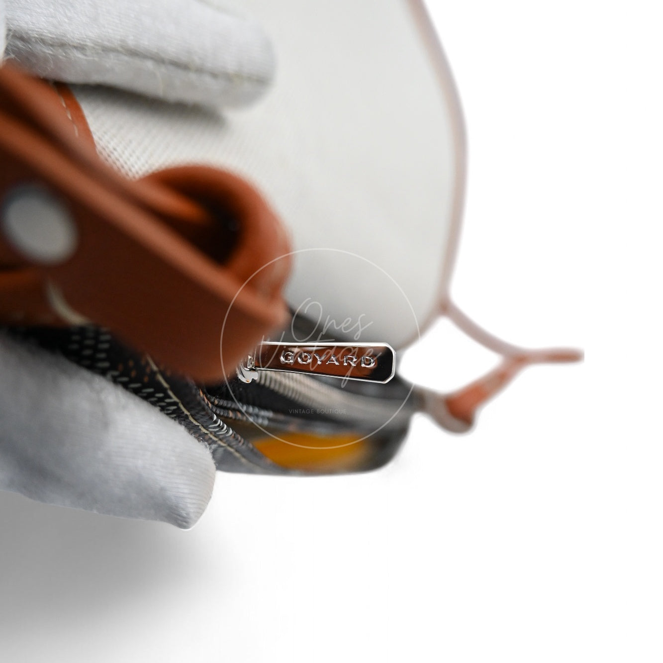 Close-up of silver-tone zipper pull engraved with GOYARD logo on Plumet bag