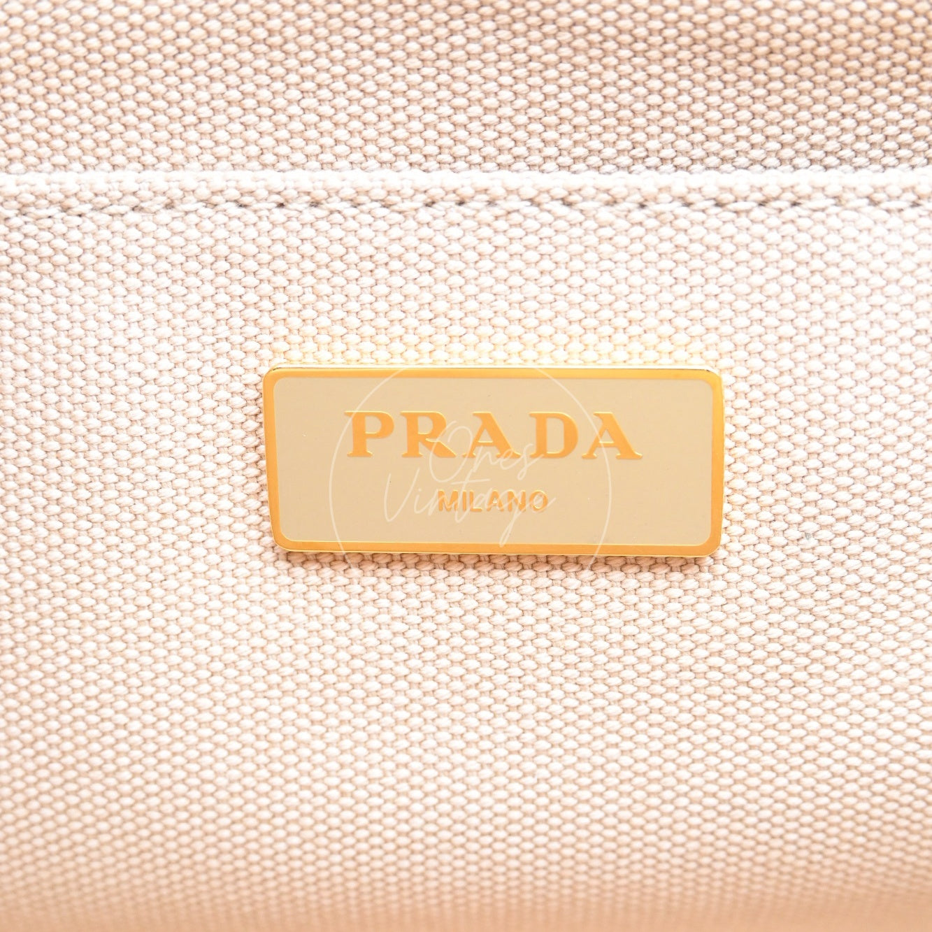 Gold PRADA MILANO logo plate inside the canvas lining of a vintage bag