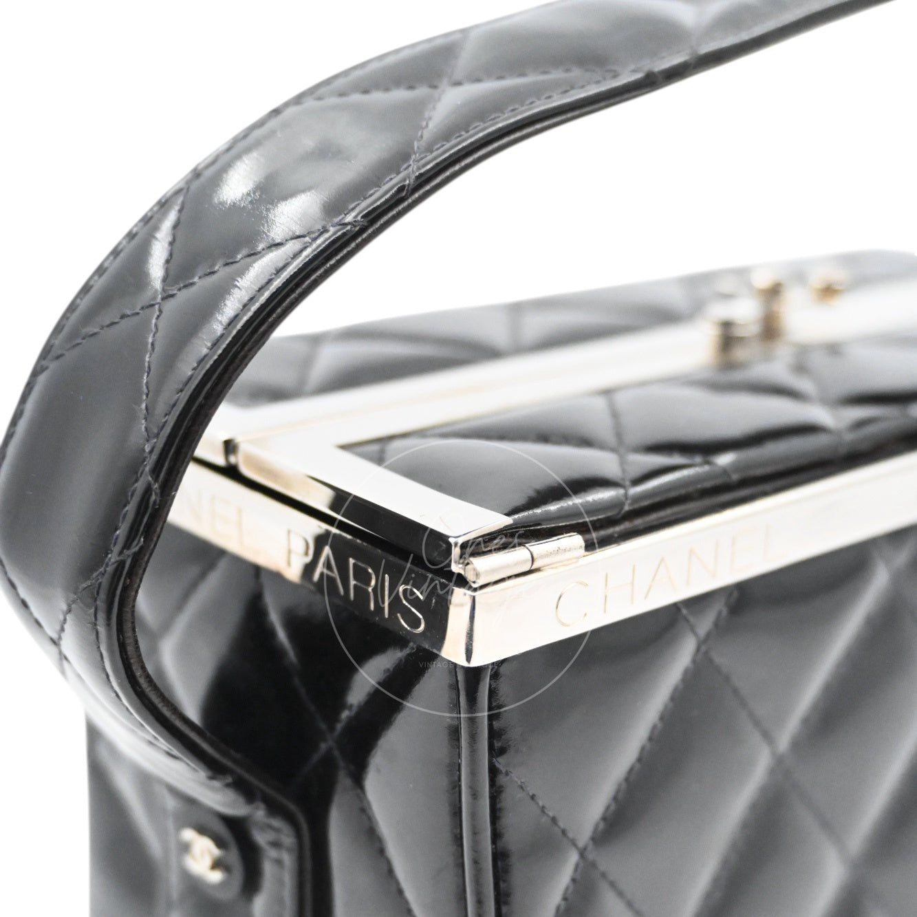 Close-up of engraved CHANEL PARIS silver-tone metal frame closure on vintage leather bag