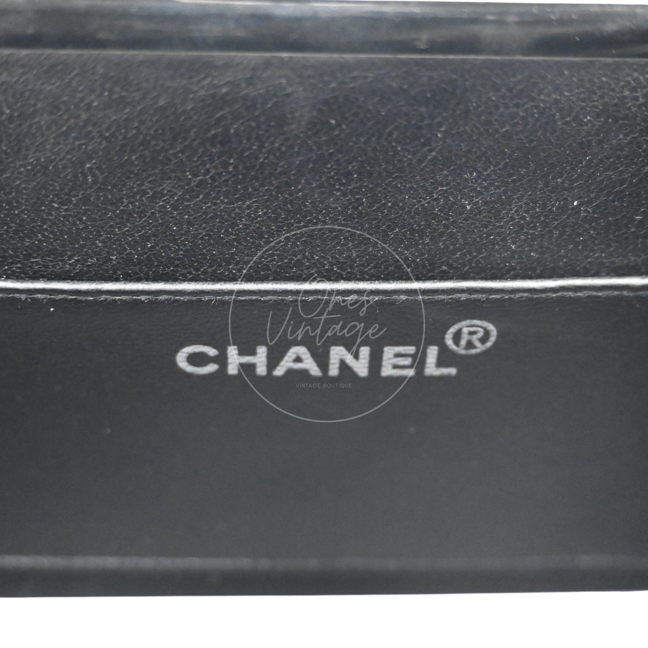 Silver foil MADE IN FRANCE logo stamp inside the black leather lining of a vintage bag