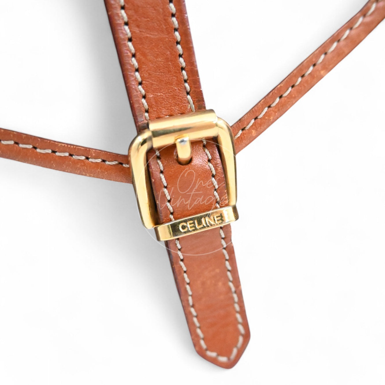 Close-up of engraved CELINE logo on the gold-tone buckle of a vintage mini pouch