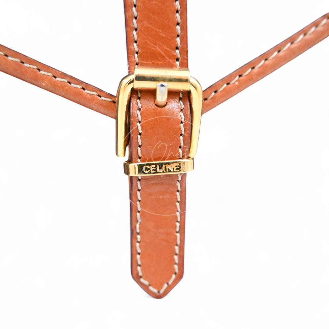 Close-up of engraved CELINE logo on the gold-tone buckle of a vintage mini pouch
