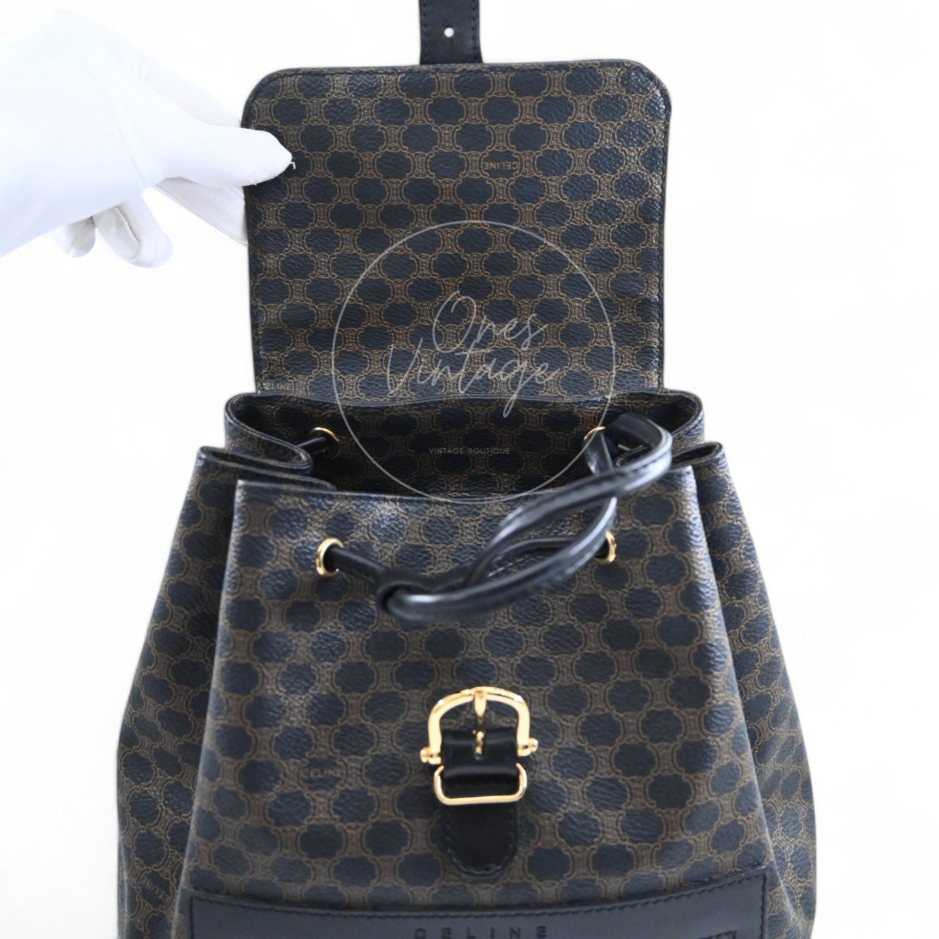 Open view of Celine vintage black macadam backpack showing interior flap and gold-tone buckle closure