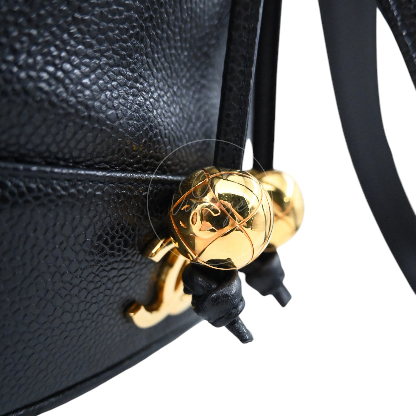 Close-up of gold ball with CC logo and drawstring tassel on vintage Chanel bag