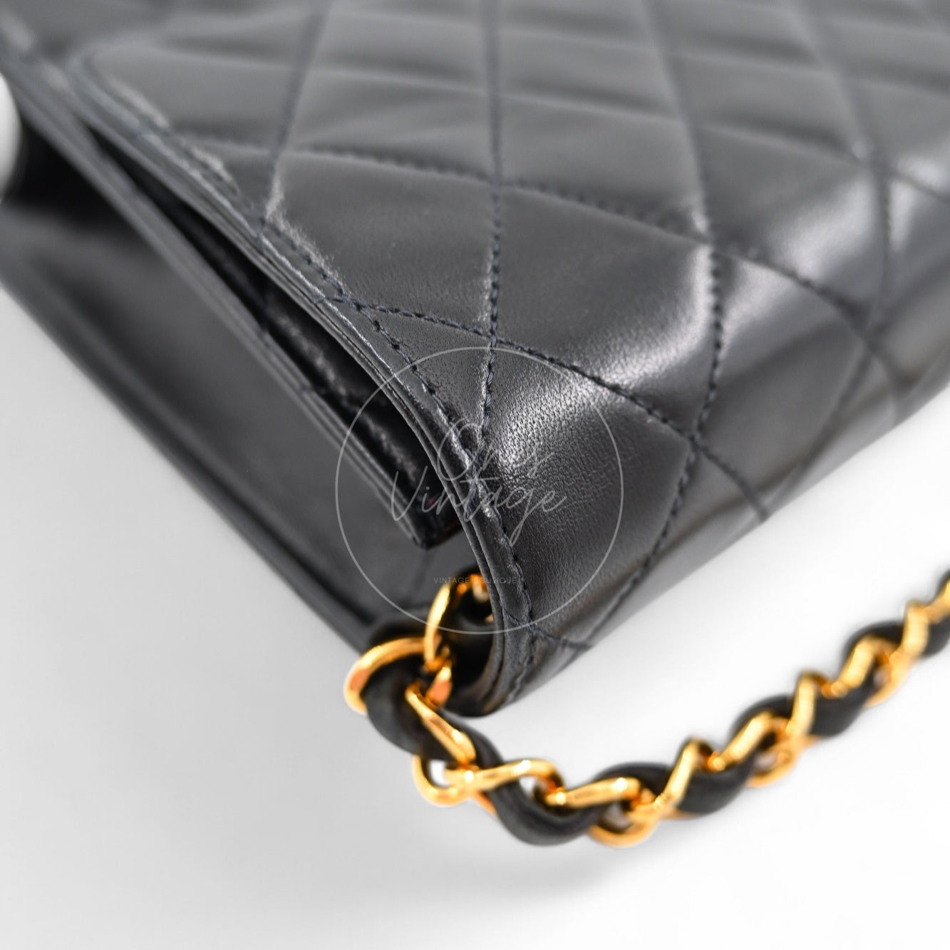 Side view of Chanel vintage black leather flap bag showing interwoven chain strap detail