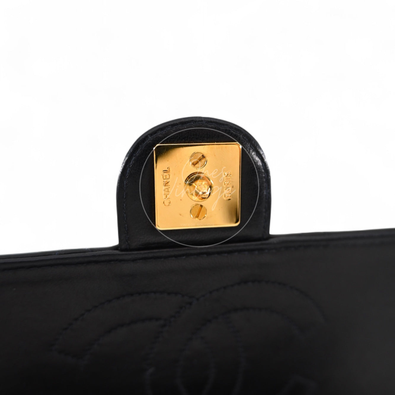 Close-up of gold-tone hardware plate with CHANEL PARIS engraving inside the flap