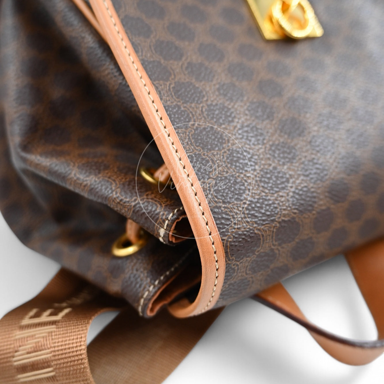 Side view of vintage Céline backpack showing leather piping, grommets, and strap attachment