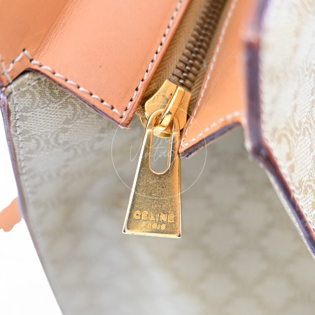 Close-up of vintage gold-tone zipper pull engraved with CELINE PARIS logo