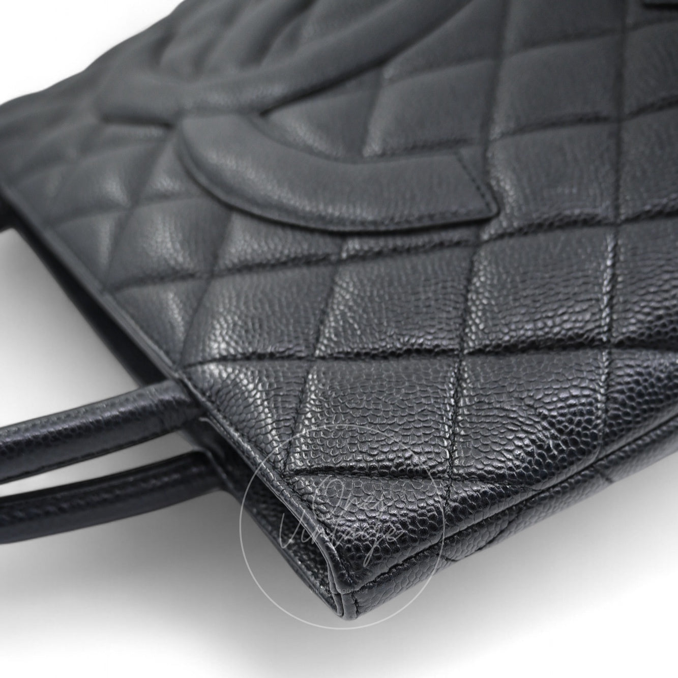 Angled side view of Chanel vintage Medallion bag showing caviar leather texture and lower corner