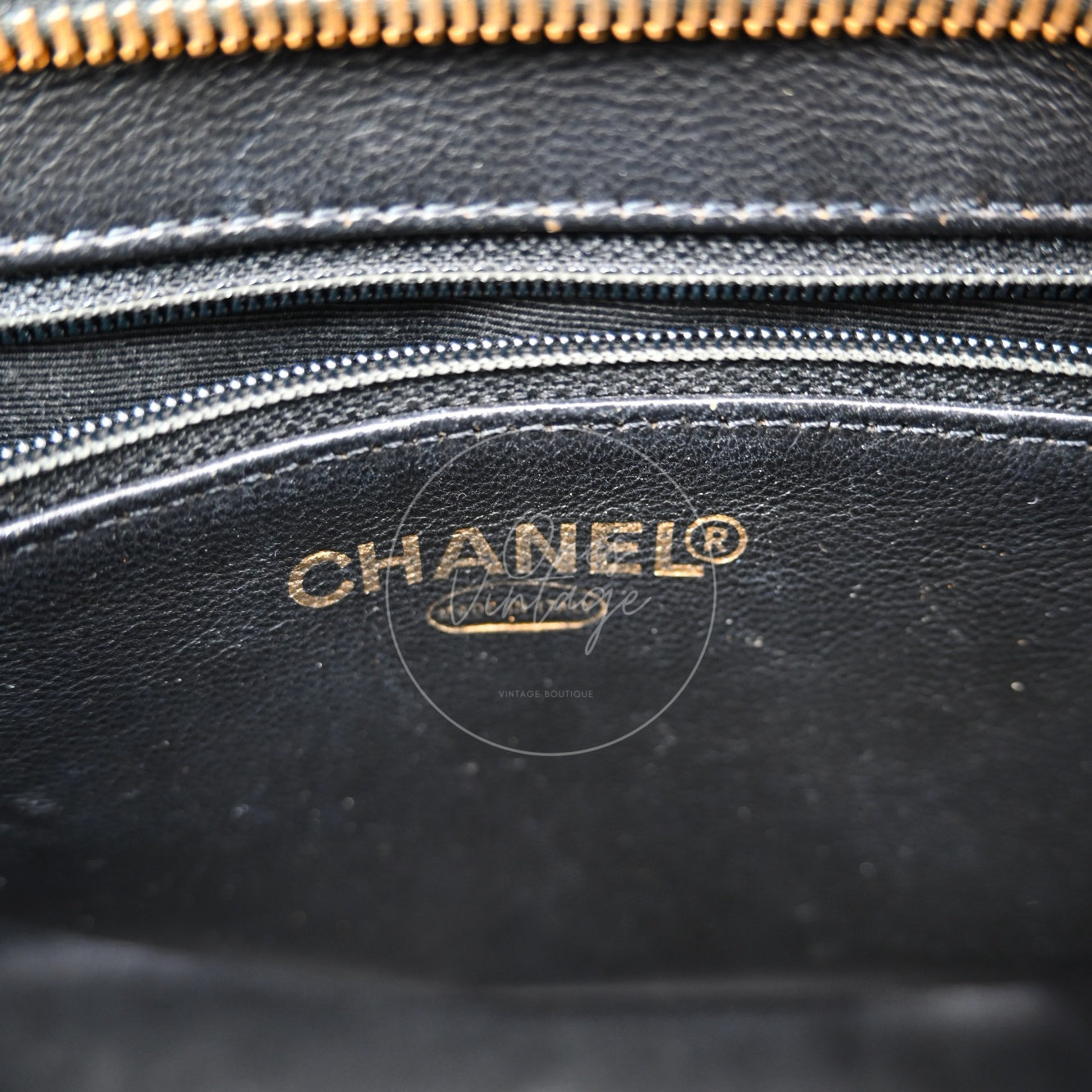 Gold foil CHANEL logo stamp on the interior leather lining of a vintage tote bag