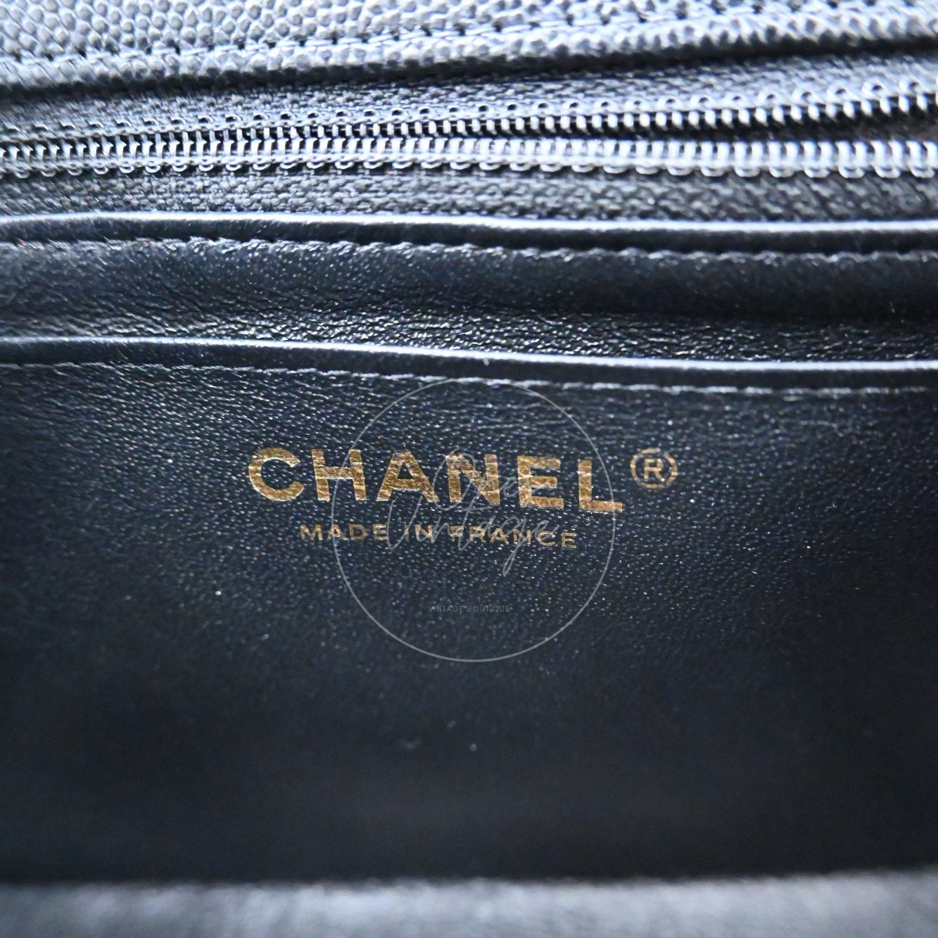 Gold foil CHANEL MADE IN FRANCE logo stamp inside the black leather lining of a classic bag