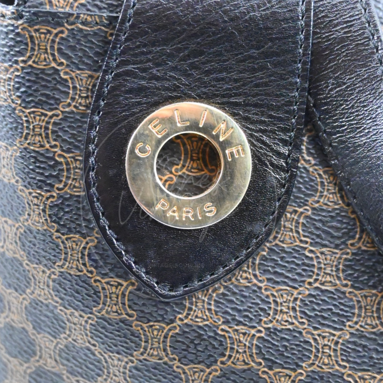 Close-up of engraved CELINE PARIS gold-tone metal ring on black Macadam bag