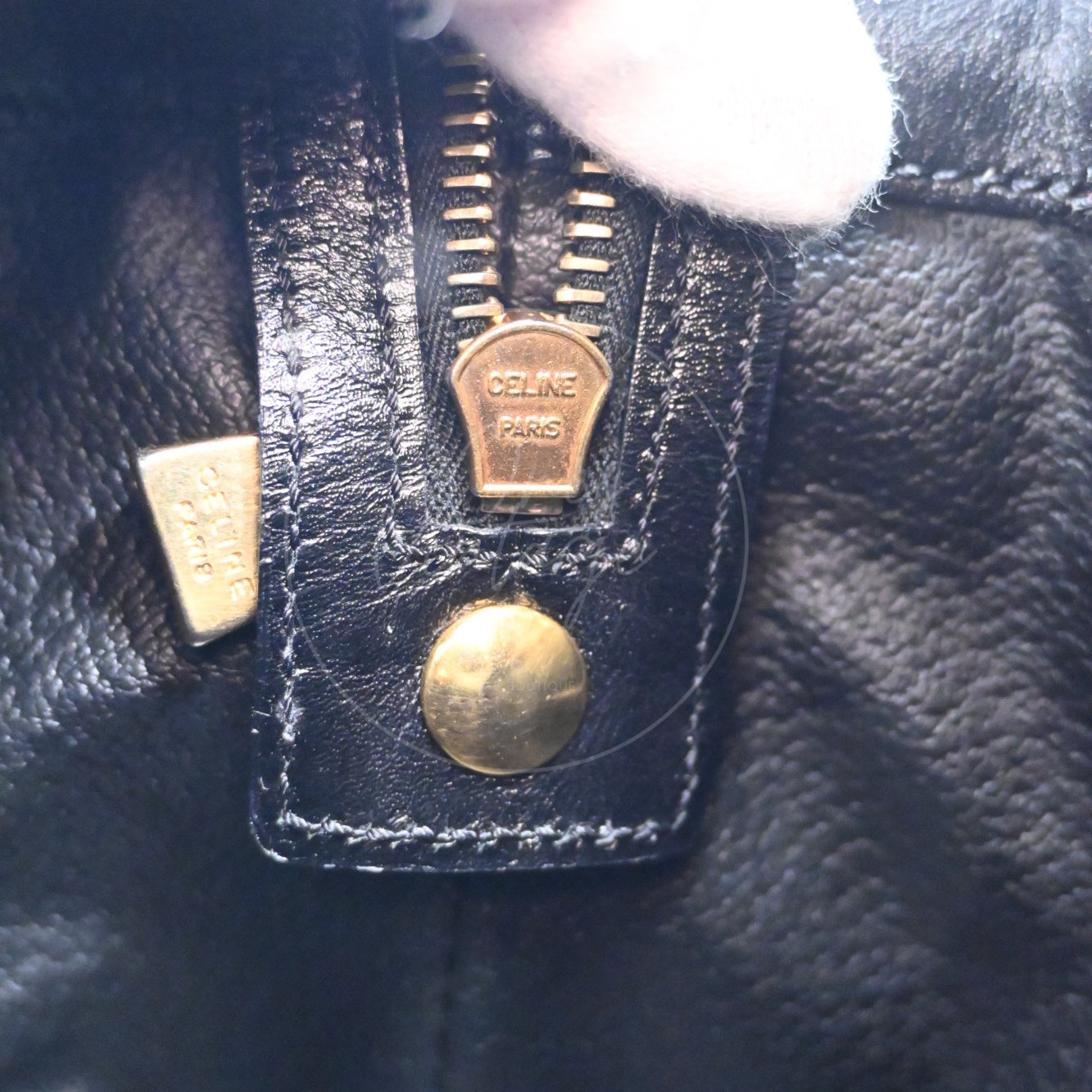 Close-up of vintage gold-tone zipper pull engraved with CELINE PARIS logo