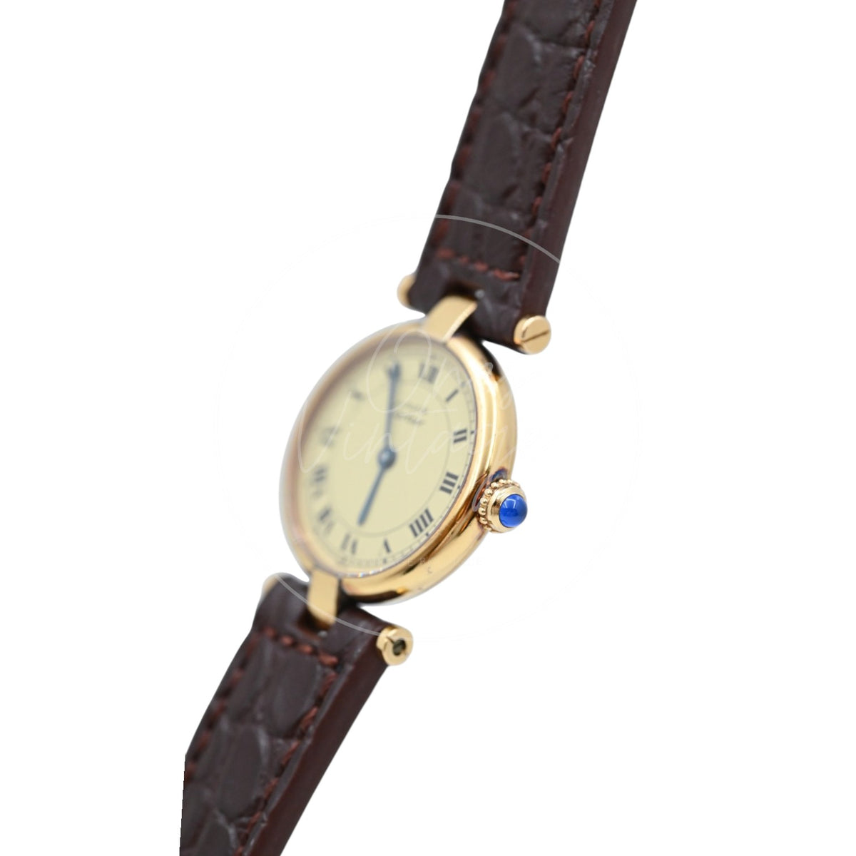 Cartier Must Vendôme SM quartz watch with ivory Roman numeral dial and brown leather strap, angled crown-side view with blue cabochon