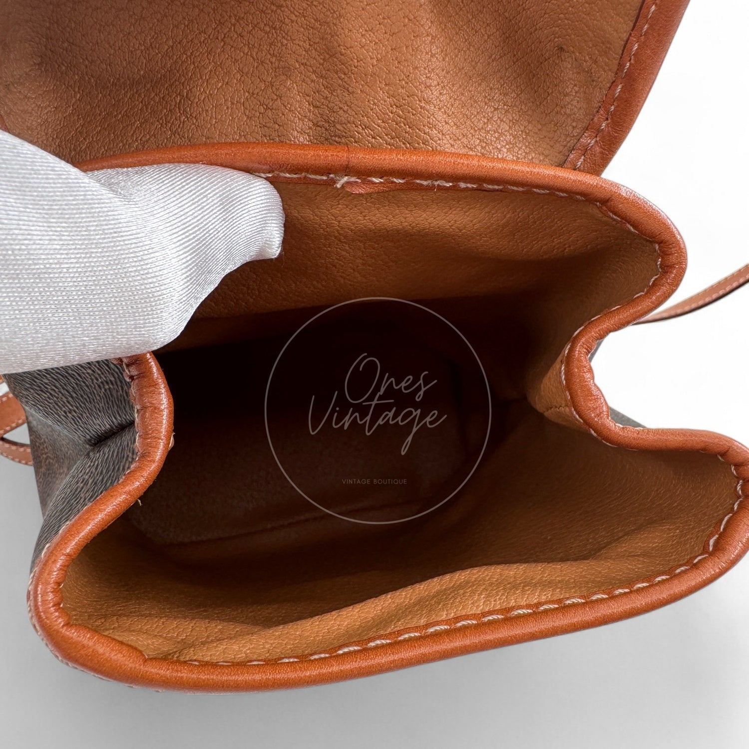 Interior view of open Céline vintage mini macadam pouch showing tan leather lining