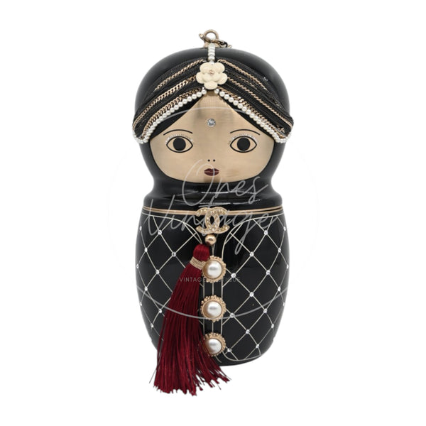 Chanel Paris-Bombay Métiers d’Art Matryoshka Doll minaudière in black resin with gold-tone hardware, Series 14, front view with pearl headpiece and burgundy tassel