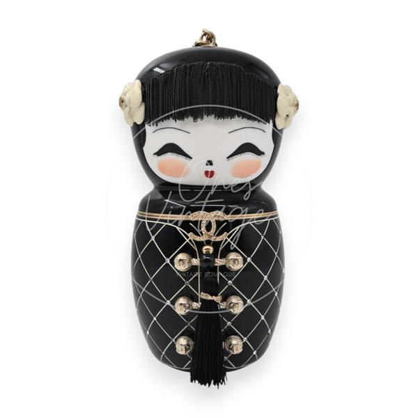 Chanel Paris-Shanghai Doll Evening Bag in black resin with gold-tone hardware, front view with floral hair ornaments and decorative closure