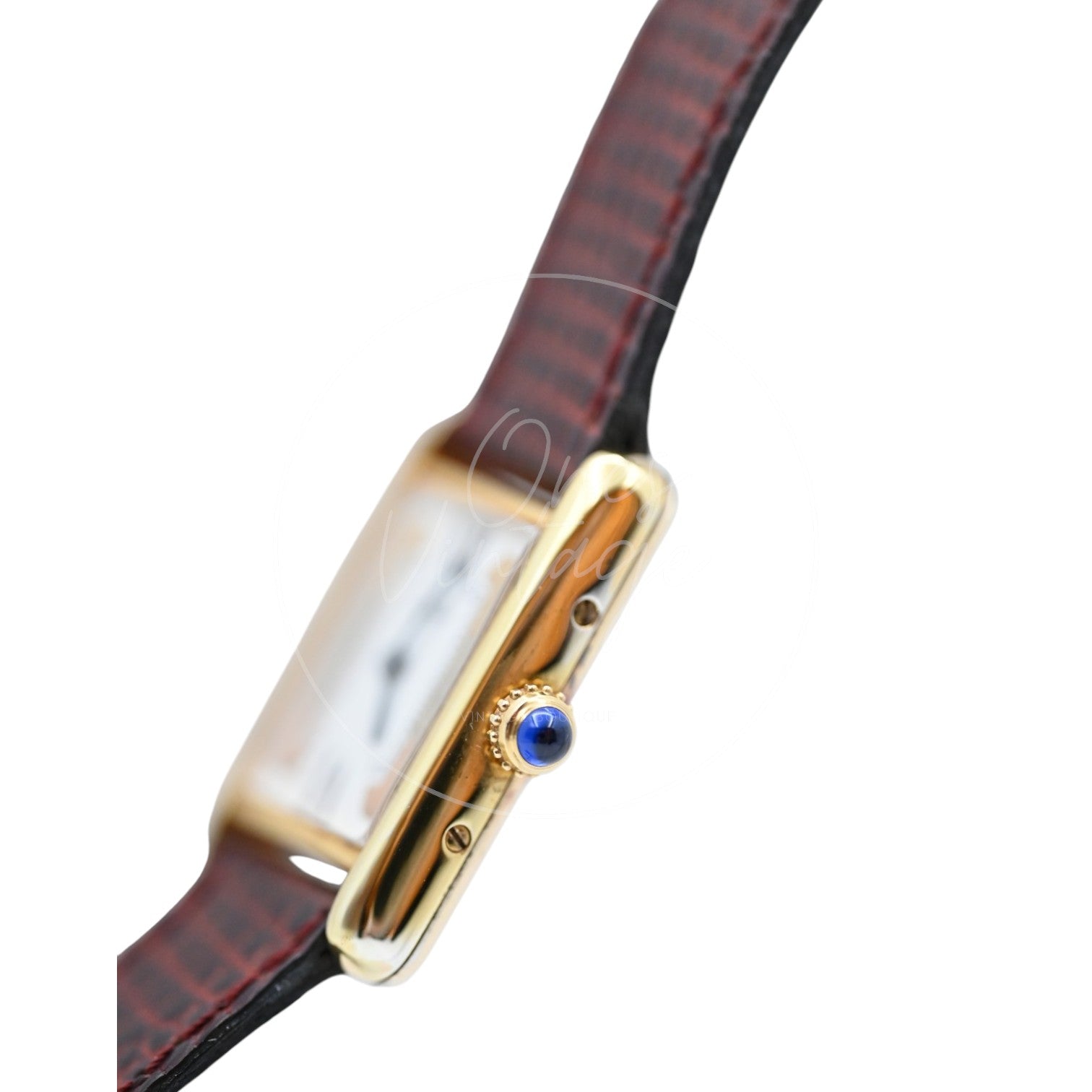 Cartier Must de Tank Trinity dial quartz watch with maroon lizard-pattern strap, angled crown-side view with blue cabochon