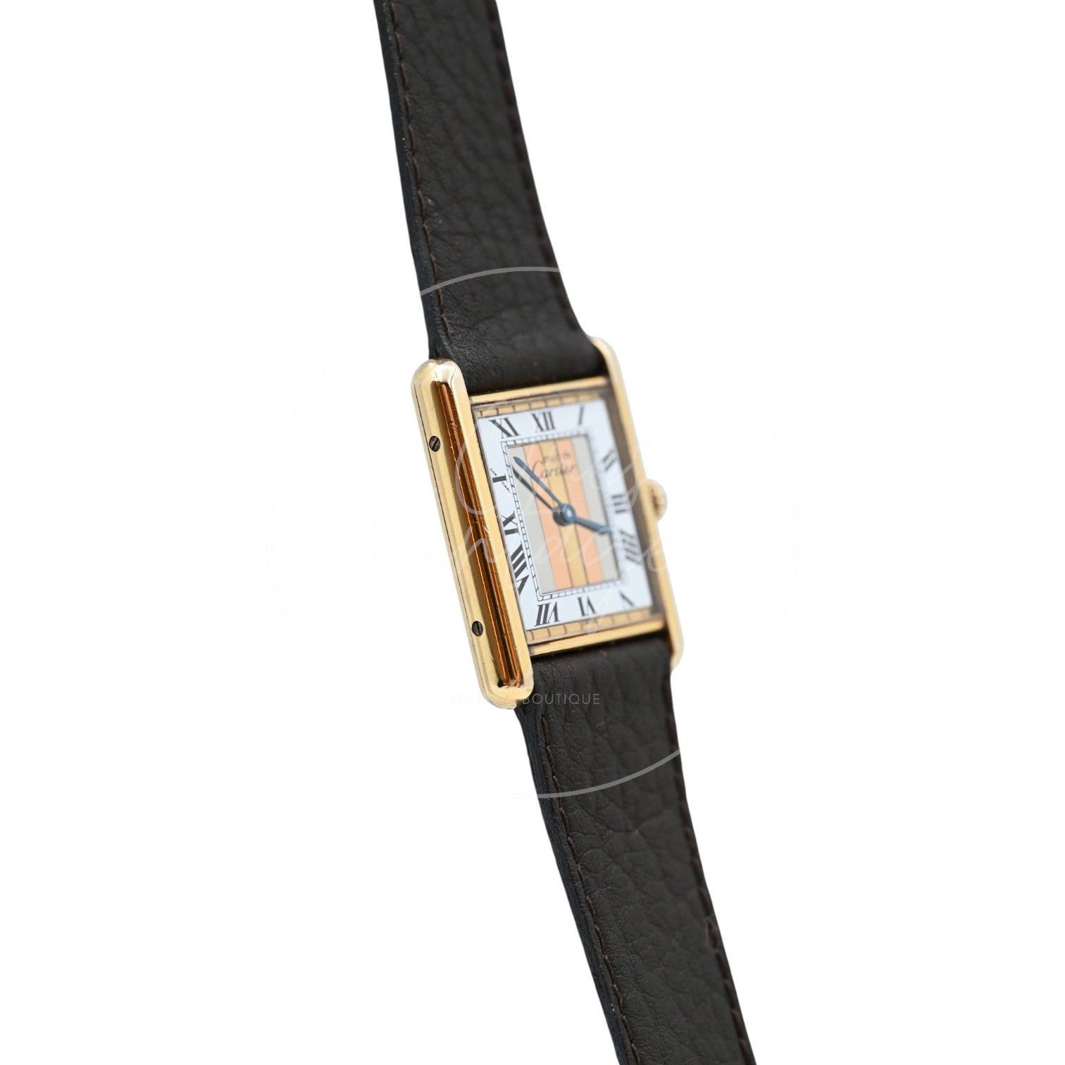 Cartier Must de Tank Trinity dial quartz watch with dark brown leather strap, angled opposite profile of the gold-tone case and dial